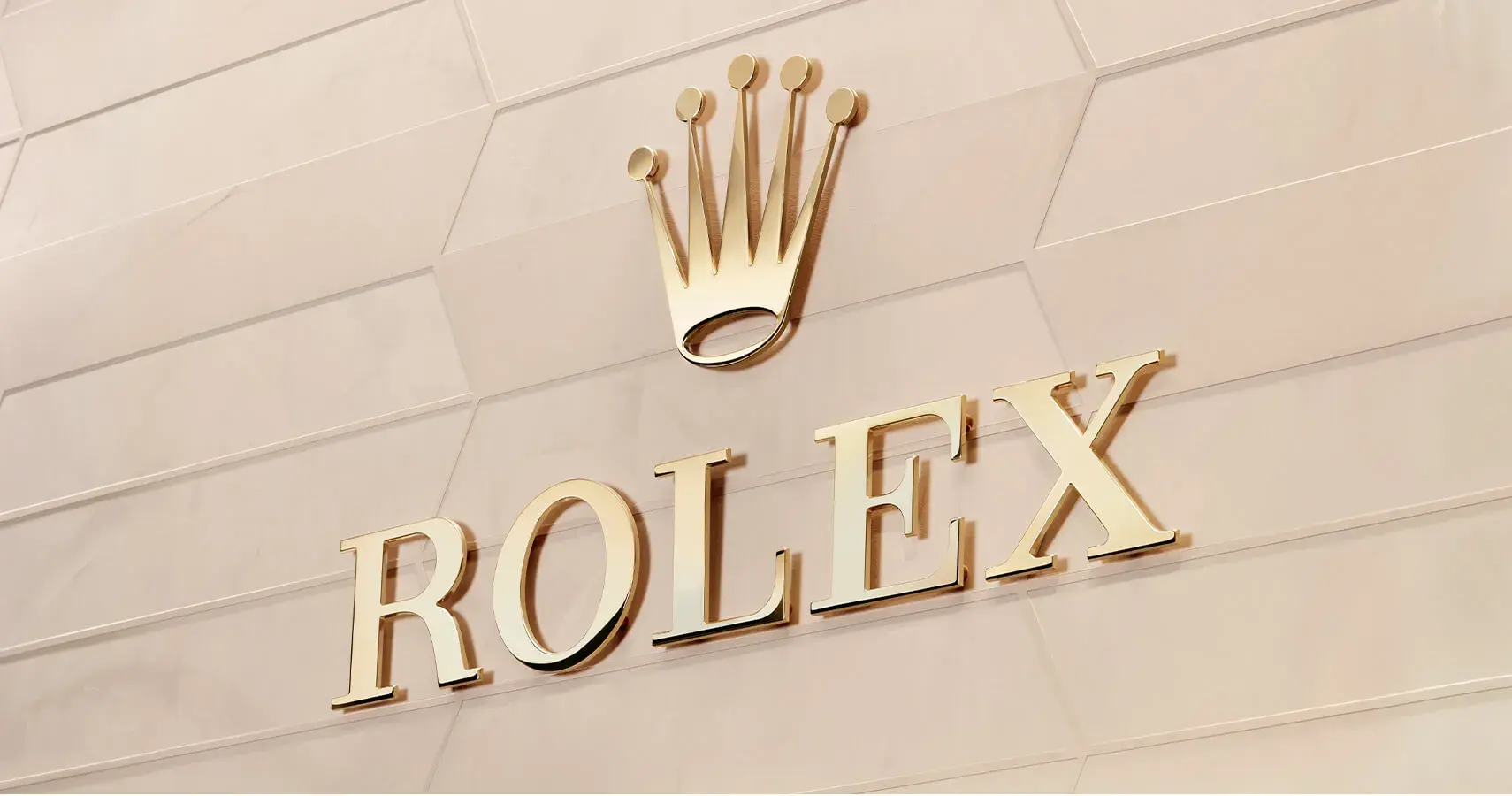 The gold Rolex logo on a tan tile wall